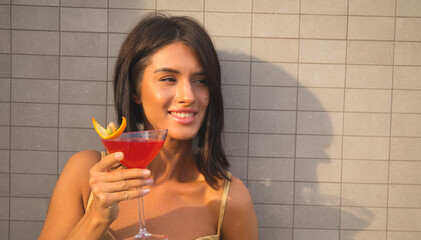 side view of young woman holding margarita cocktail