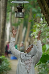 Asian female model in white hijab is in the park