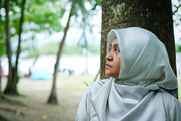 Asian female model in white hijab is in the park