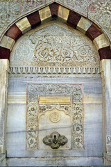 Sultan Ahmed III Fountain in Istanbul: one of the marble walls decorated with carvings close-up. The architectural heritage of the Tulip Age in Turkey - landmarks in the Ottoman Baroque style.