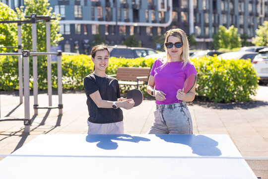 Adult woman instructor teaching girl play table tennis