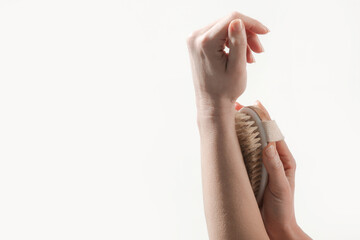 Dry body brush, Woman dry brushing body to reduce cellulite, detoxify the lymphatic system, and achieve beautiful smooth skin. Dry skin brushing as part of morning health and energy routine.