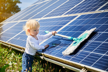 Little kid learning how to clean solar panel. Young boy learning how to care about solar station....