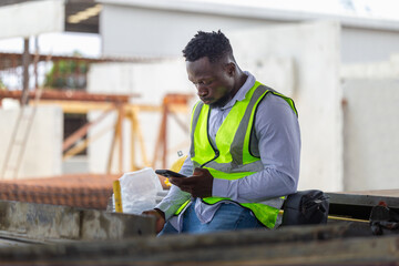 Engineer man takes a break in the precast factory site, Foreman worker using mobile smartphone at...