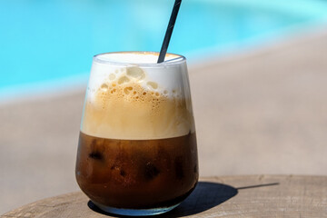 View of a delicious iced greek coffee, also known as freddo cappuccino with a straw in Ios Greece