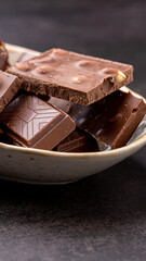 Chocolate cupcake with icing and chocolate bar in Dark lighting,Homemade delicious chocolate muffin on wooden background close-up