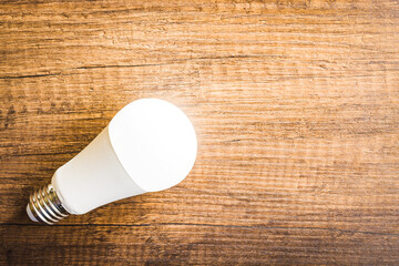 Energy saving light bulb on wooden table. Led Lightbulb. Top view.