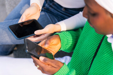 close up of the hands of two unrecognizable women using their mobile phones, concept of technology...