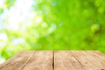 ぼやけた玉ボケの光が重なる緑の背景に木の台