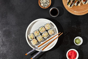 Assorted Sushi Rolls with Shrimp Tartare, Avocado, and Tobiko Caviar on a Modern Dark Surface