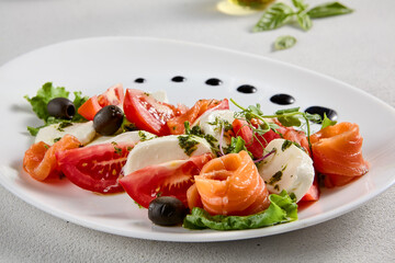 Salmon and mozzarella Caprese salad with fresh tomatoes, top view. Ideal for culinary magazines and healthy eating blogs