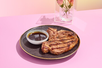 Grilled beef steak with Demi-Glace sauce; a high-end gastronomic delight against a pastel floral backdrop