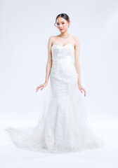 Asian young beautiful female portrait attractive model of bride wearing fashion wedding dress, luxury delight make-up, hairstyle, standing looking camera isolated white background studio indoor photo
