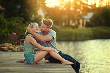 Love relationship, smile and couple by pier with lake, support together and weekend break for...