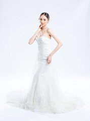 Fototapeta premium Asian young beautiful female portrait attractive model of bride wearing fashion wedding dress, luxury delight make-up, hairstyle, standing looking camera isolated white background studio indoor photo
