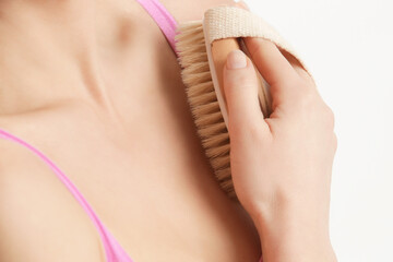 Dry body brush, Woman dry brushing body to reduce cellulite, detoxify the lymphatic system, and achieve beautiful smooth skin. Dry skin brushing as part of morning health and energy routine.