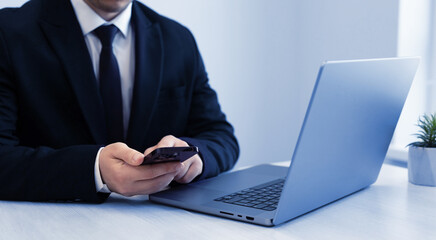 Businessman holding a smartphone in his hands on the work table in the office. Concept of news,check e-mail,social media, blogger,marketing.