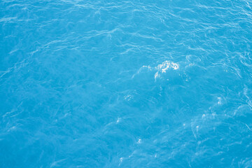 Naklejka premium Beautiful texture of calm sea waves in the middle of the sea during the day. view from the boat of calm sea waves