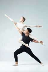 Flexible Passionate International Sportive Couple of Asian Man and Caucasian Woman Performing As Ballet Dancers On Grey in Studio During Suppots As Classical Dance © danmorgan12