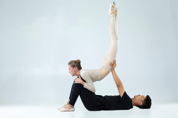 Dance Ideas. Flexible Passionate International Sportive Couple of Asian Man and Caucasian Woman Performing As Ballet Dancers On Grey in Studio During Suppots As Classical Dance © danmorgan12