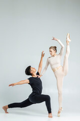 One Sensual Passionate Professional International Sportive Couple of Asian Man and Caucasian Woman Performing As Ballet Dancers On Grey in Studio During Suppots As Classical Dance © danmorgan12