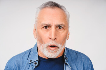 Shocked gray-haired bearded adult man posing looking at camera isolated on white background
