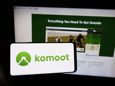 Stuttgart, Germany - 05-23-2024: Person holding smartphone with logo of German route planning app company komoot GmbH in front of website. Focus on phone display.