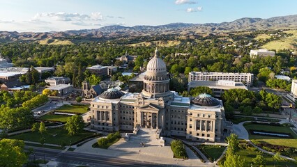 Obraz premium The Boise State Capital building surrounded by greenery and other buildings in early morning