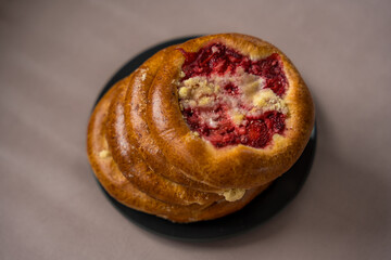 Czech round pies kolaches with strawberries and cottage cheese on a beige background.
