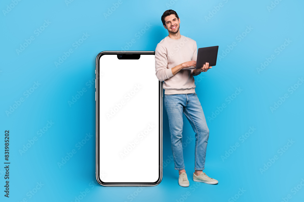Poster full size photo of intelligent man wear sweatshirt hold laptop stand near smartphone display empty s