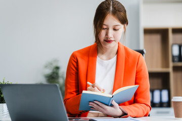 young Asian businesswoman, dressed in a formal suit, navigates complexities of the stock market as...