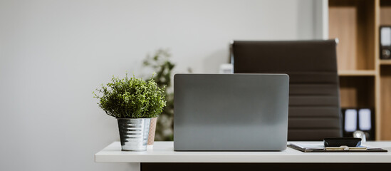 An empty, modern office space with a clean desk and sleek furniture offers a bright, comfortable workspace for business, featuring contemporary design elements and ample natural light.