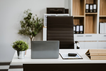 An empty, modern office space with a clean desk and sleek furniture offers a bright, comfortable workspace for business, featuring contemporary design elements and ample natural light.