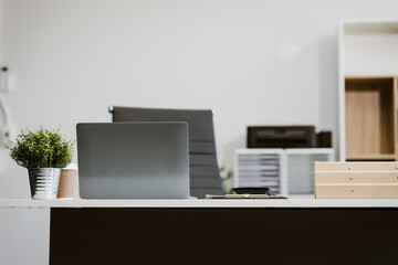 An empty, modern office space with a clean desk and sleek furniture offers a bright, comfortable workspace for business, featuring contemporary design elements and ample natural light. © Phushutter