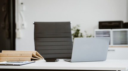 An empty, modern office space with a clean desk and sleek furniture offers a bright, comfortable workspace for business, featuring contemporary design elements and ample natural light.