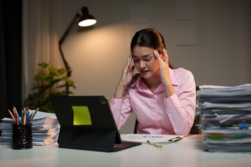Tired Asian business woman Stress from paperwork, headaches, sleepiness on piles of documents....