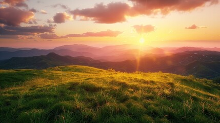 A sunset over a grassy hill with mountains in the background.