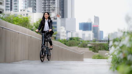 Smart businesswoman ride bicycle in downtown. Environmentalist commuting by cycling reduce carbon footprint global warming. Bike to work eco friendly alternative transportation green energy vehicle