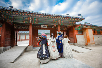Tourists in national clothes walk in Gyeongbokgung Palace