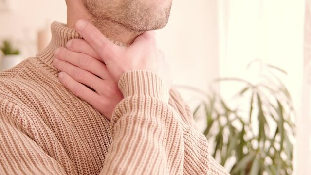 close-up young male neck, man patient holding affected area, experiencing throat pain, Health concern, loss of voice, various causes, medical attention and treatment for condition, tonsillitis