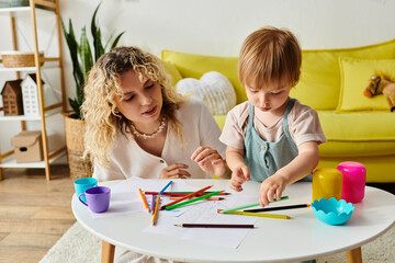 A curly mother and her toddler daughter sit at a table using crayons for Montessori education.