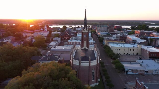 Natchez, Mississippi, USA - April 21, 2024: Sunset light shines on a historic church and landscape of downtown Natchez.