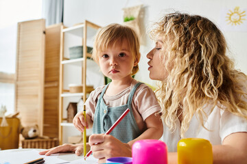A curly mother and her toddler daughter engage in the Montessori method of education at a table.