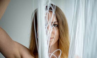 Fototapeta premium portrait of sensual loving sexy erotic nude woman standing by the window in behind string curtain