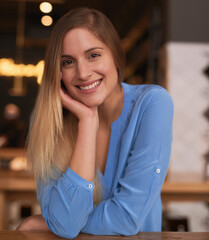 Portrait, smile and woman in cafe, relax and weekend break with adventure, explore and peace. Face, person and girl in restaurant, cheerful and vacation with coffee shop, interior and casual outfit