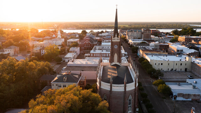 Natchez, Mississippi, USA - April 21, 2024: Sunset light shines on a historic church and landscape of downtown Natchez.