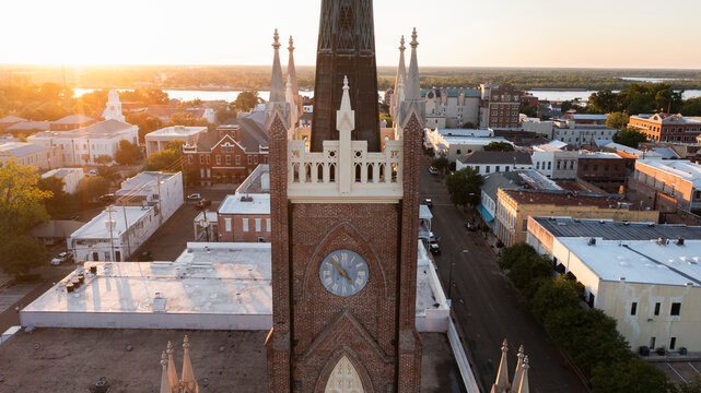 Natchez, Mississippi, USA - April 21, 2024: Sunset light shines on a historic church and landscape of downtown Natchez.