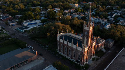 Natchez, Mississippi, USA - April 21, 2024: Sunset light shines on a historic church and landscape of downtown Natchez.