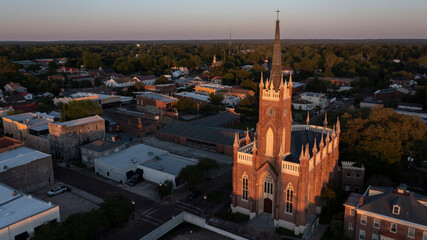Fototapeta premium Natchez, Mississippi, USA - April 21, 2024: Sunset light shines on a historic church and landscape of downtown Natchez.