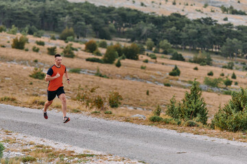 Obraz premium Determined Athlete Running Through Rugged Mountain Terrain at Sunrise.